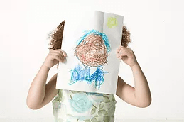 Dziecko przykładające sobie rysunek do twarzy