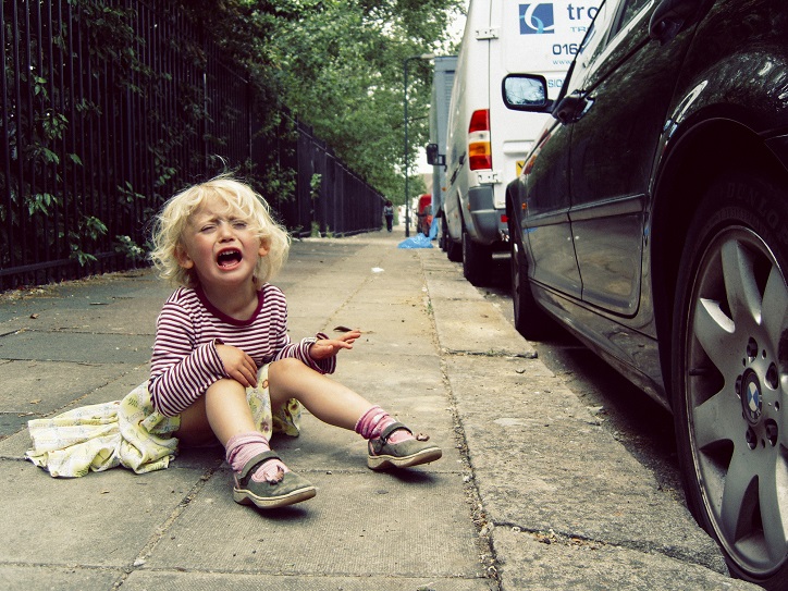 krzycząca dziewczynka siedząca na chodniku